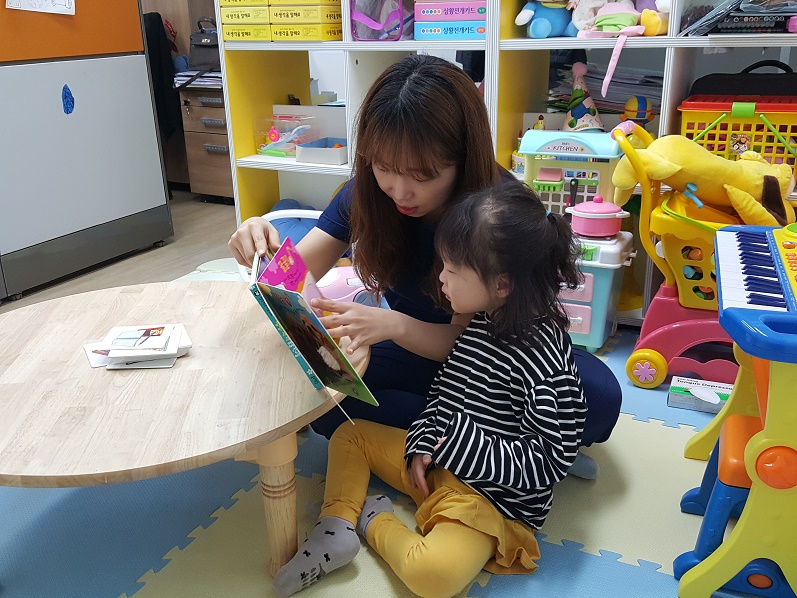 언어치료사가 아동과 함께 그림책을 읽고 있는 모습