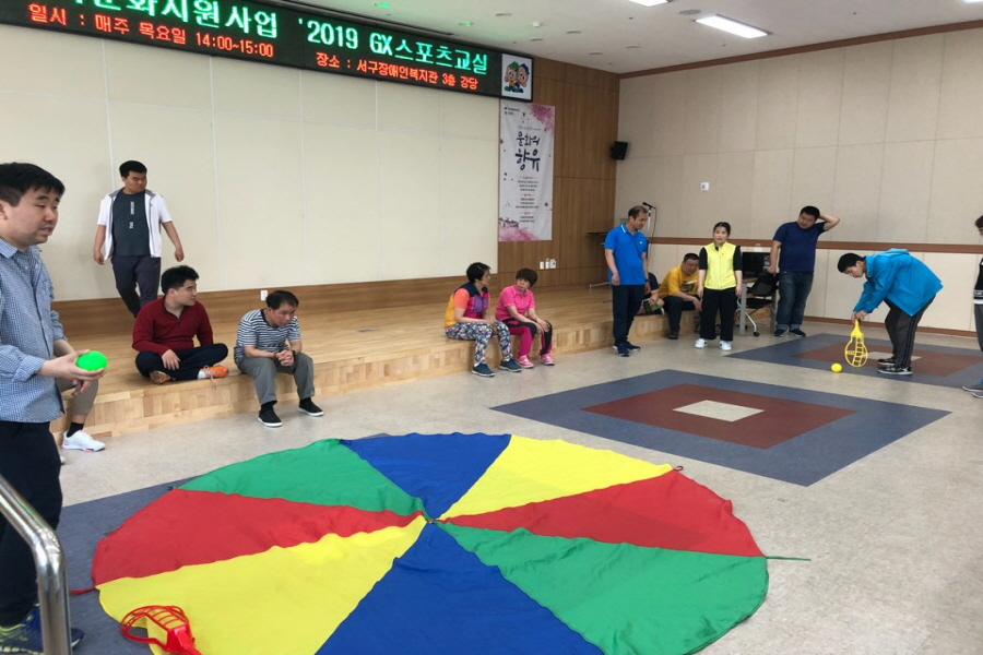 8a3c369d67b7b04b1293abf379da83b2_1560774513_4492.jpg 스포츠교실에 참여한 이용자들이 교구를 활용하여 파라슈트 볼링을 진행하는 모습