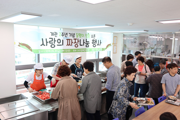 짜장나눔 행사를 맞이 하여 방문한 사람들이 차례로 짜장면을 받고 있는 모습