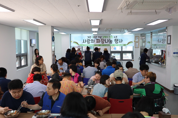 짜장면을 맛있게 먹으며, 옆사람과 이야기를 나누고 있는 모습