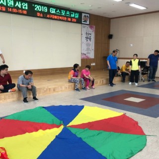 스포츠교실에 참여한 이용자들이 교구를 활용하여 파라슈트 볼링을 진행하는 모습