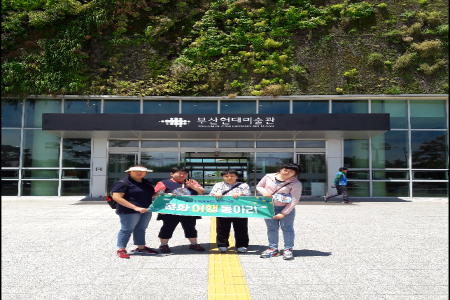 주간활동 이용자들이 부산현대미술관 입구에서 현수막을 들고 찍은 사진