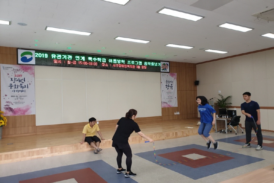 728a794018480fd704f0d2e139c073c8_1564474434_8905.jpg 음악줄넘기에 참여한 학생들이 강사와 함께 긴줄넘기를 활용하여 줄넘기를 하고 있는 모습