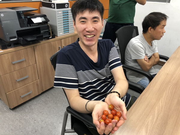 수확한 방울토마토를 손에 들고 환하게 웃음을 지어보이는 훈련생의 모습