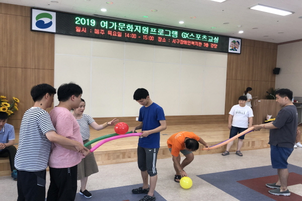 GX스포츠교실에서 공넘기기 놀이를 하고 있는 사람들의 모습