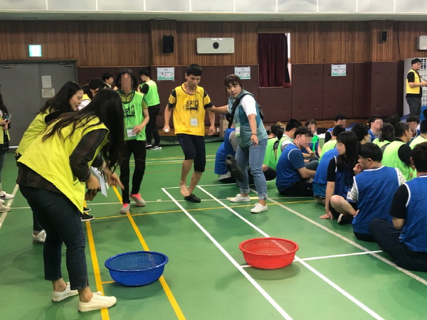 연합체육대회에서 바구니에 골넣기 놀이를 하고 있는 사람들의 모습