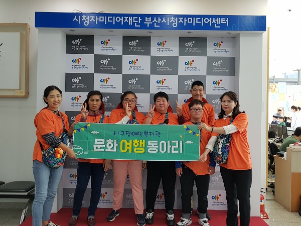 센터 내부에서 현수막을 들고 찍은 기념사진