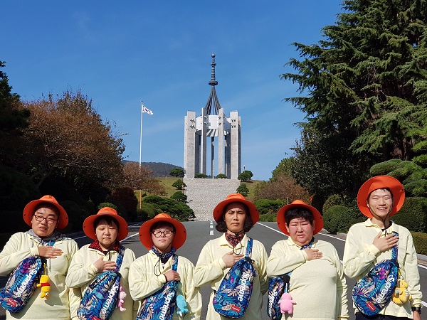 중앙공원 충혼탑을 배경으로 찍은 기념사진 이용자들이 왼쪽가슴에 손을 올리고 있다
