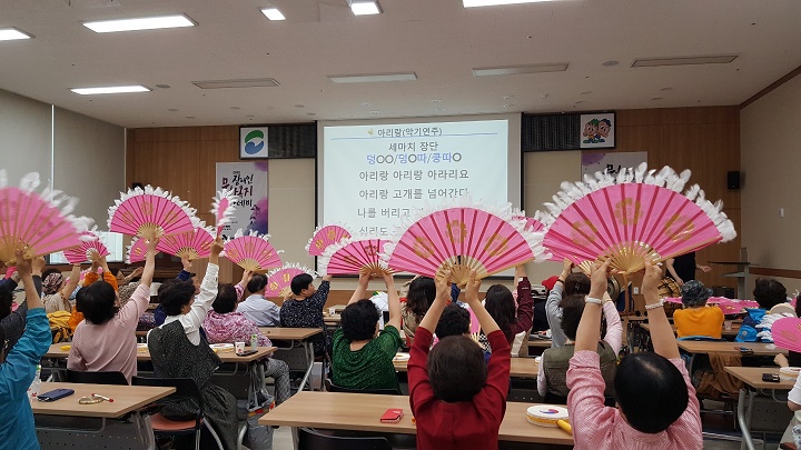 장애인문화복지아카데미 수강생들이 전통노래를 부르며 부채를 높이 들고 있는 모습