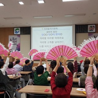 장애인문화복지아카데미 수강생들이 전통노래를 부르며 부채를 높이 들고 있는 모습
